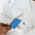 A person holding a card in front of a computer