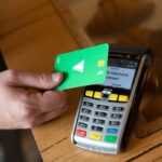 a person holding a credit card next to a calculator