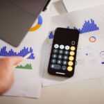 a calculator sitting on top of a table next to a laptop