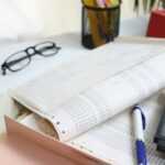Desk with papers, glasses, calculator, and office supplies