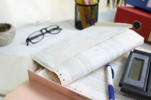 Desk with papers, glasses, calculator, and office supplies